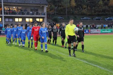 Der ausgezeichnete Schiedsrichter Sinan Karatas führt die beiden Mannschaften zum ersten Spiel im neuen Stadion auf das Spielfeld